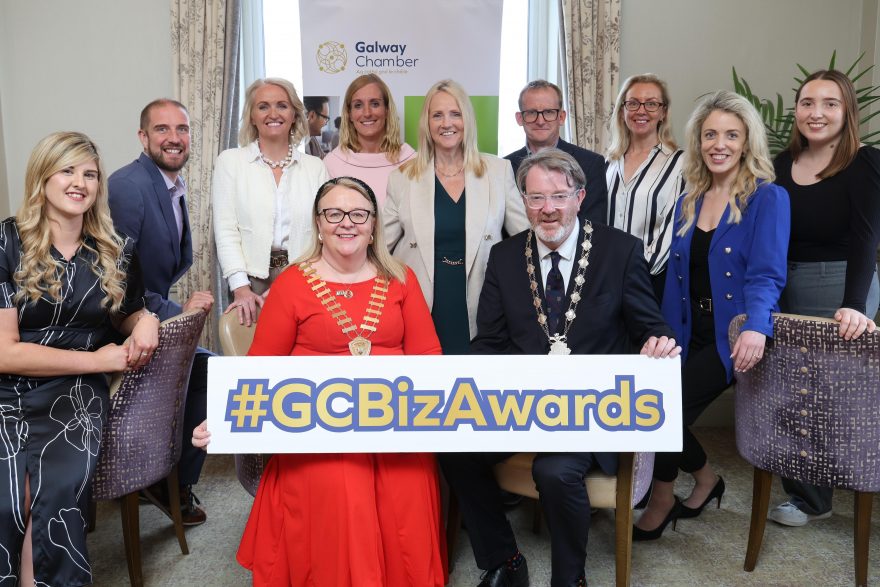 A group of Galway Chamber members posing with a sign that says #GCBizAwards